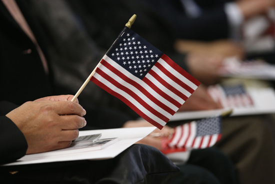 NEW YORK, NY - JANUARY 17: Immigrants wait for a naturalization ceremony held at the U.S. Citizenship and Immigration Services (USCIS) office on January 17, 2014 in New York City. One hundred and fifty-three people from 41 countries became American citizens at the event. (Photo by John Moore/Getty Images)